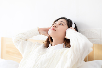 在卧室里听音乐的中国年轻女性