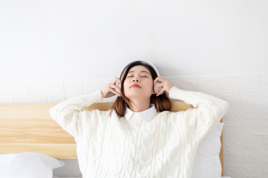 在卧室里听音乐的中国年轻女性