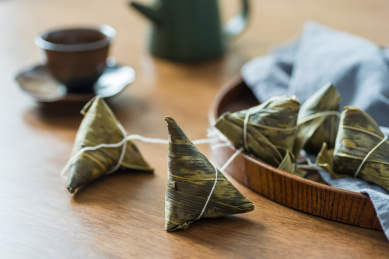 落地窗前的的木桌上放着的粽子和茶水