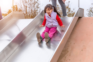 小女孩在游乐场里玩滑梯