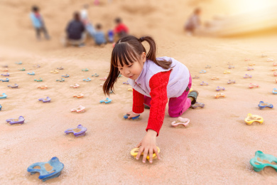 小女孩在游乐场里玩攀岩