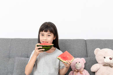 客厅里一个中国小女孩在吃西瓜