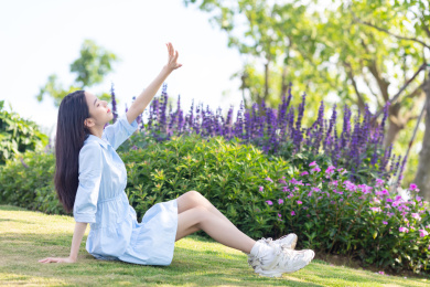公园里一名年轻女性坐在草地上休息