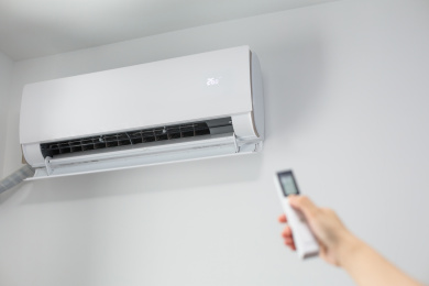 手拿遥控器操作开关空调