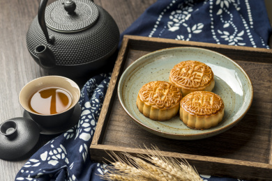中秋节传统美食月饼与茶水特写古窗棂木桌面