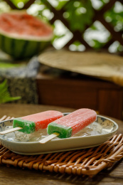 放在瓷盘冰块上的两只西瓜冰棒夏天