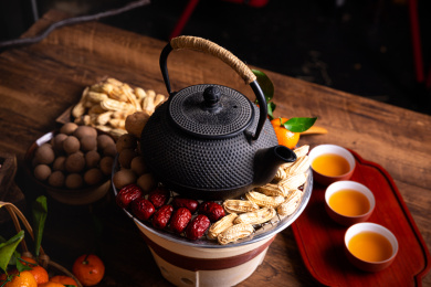 放在小泥炉上的铁壶和坚果水果在煮茶