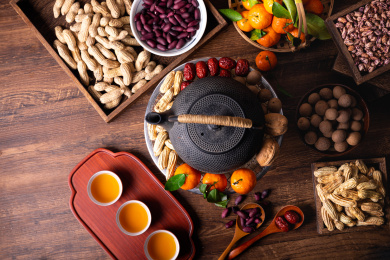 桌子上放着铁壶和小泥炉水果坚果俯拍