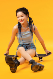 个性年轻女孩坐在滑板上