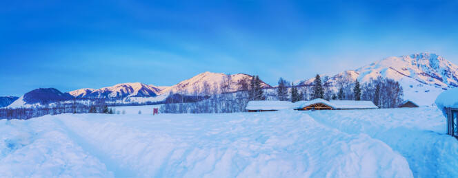 中国新疆禾木的村庄和雪山和晚霞美景