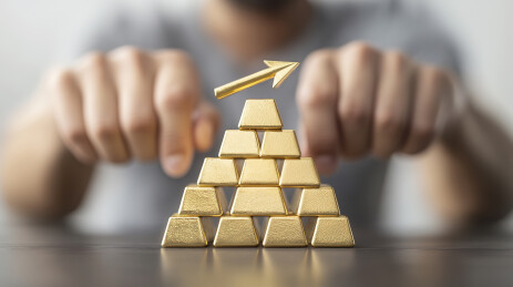 桌面上的一摞金条和向上的箭头黄金投资概念